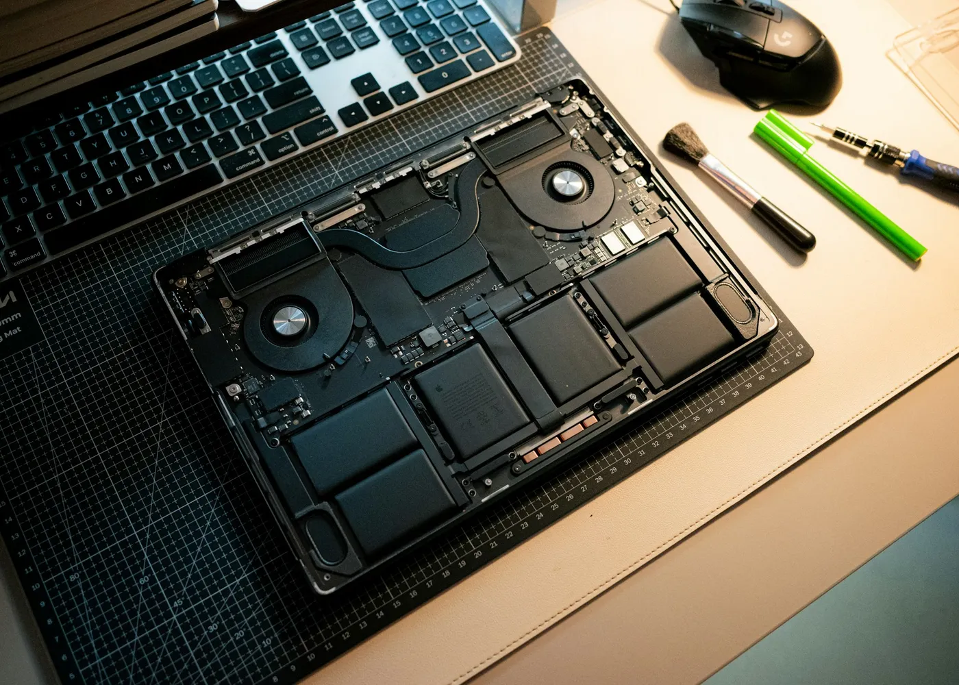 Geöffneter Laptop mit sichtbaren Bauteilen auf einer Schneidematte