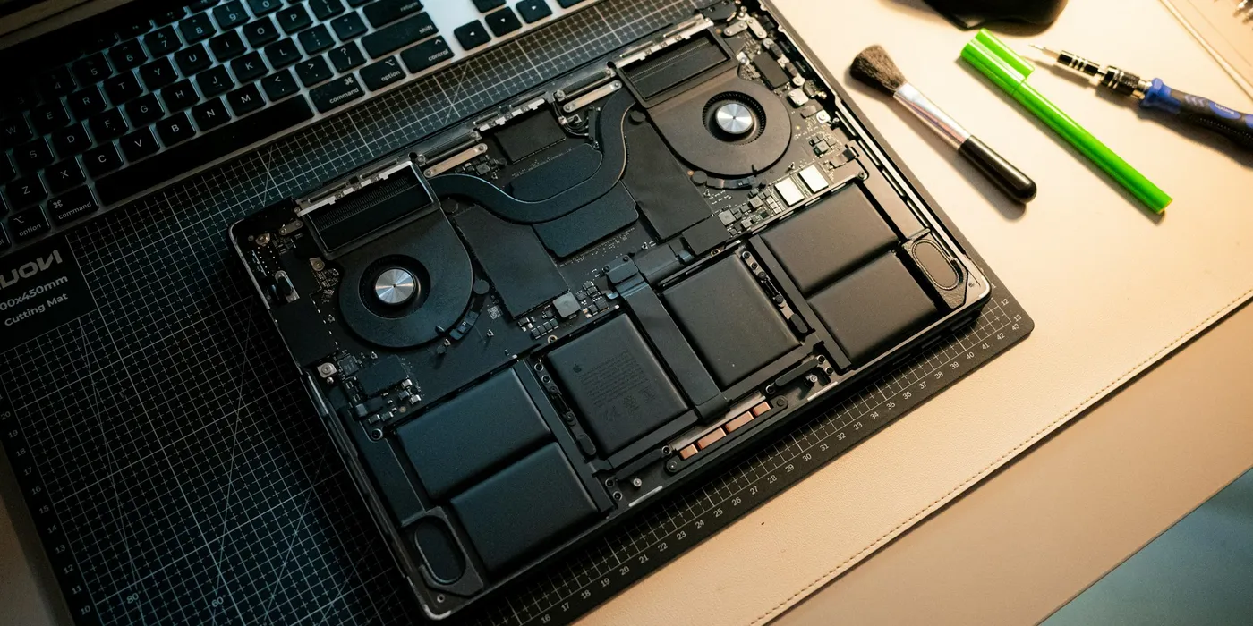 Geöffneter Laptop mit sichtbaren Bauteilen auf einer Schneidematte